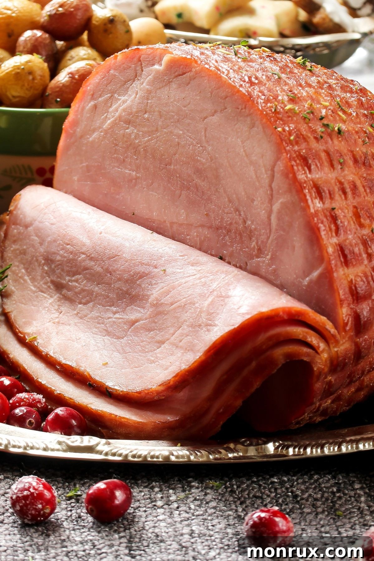 Sliced uncured ham on a rustic wooden table, garnished with fresh herbs and vegetables, suggesting a healthy and delicious meal.