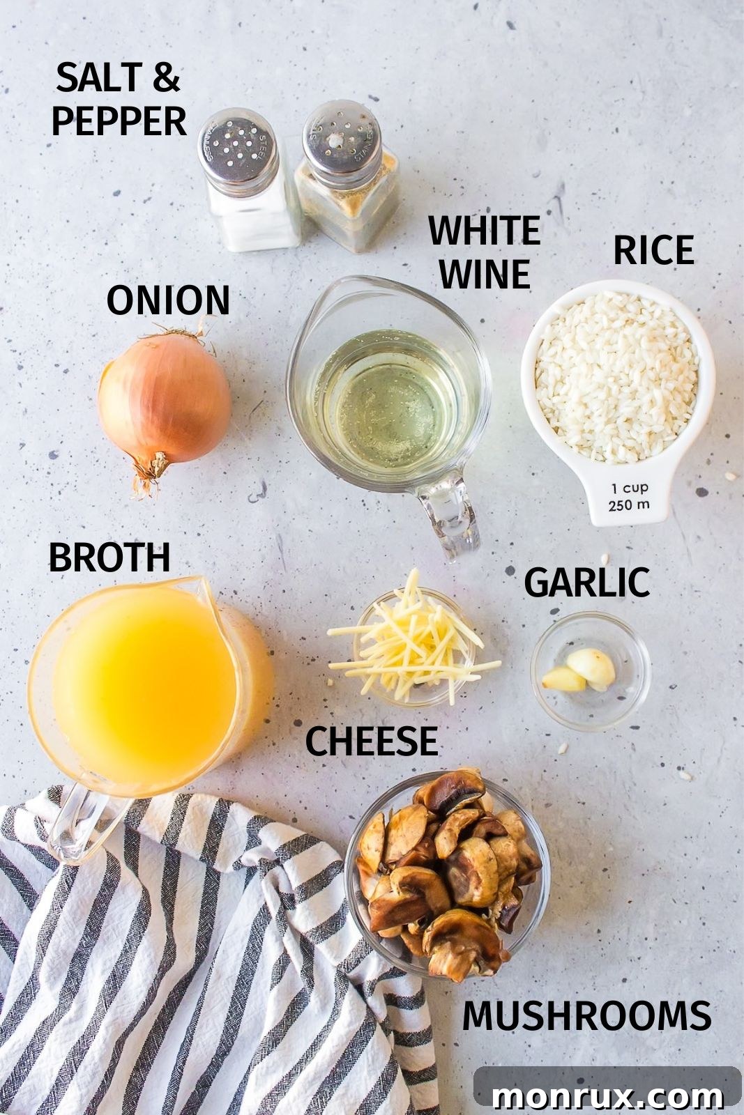 A selection of fresh ingredients including Arborio rice, mushrooms, onion, garlic, and broth laid out on a white countertop, ready for gluten-free risotto preparation.