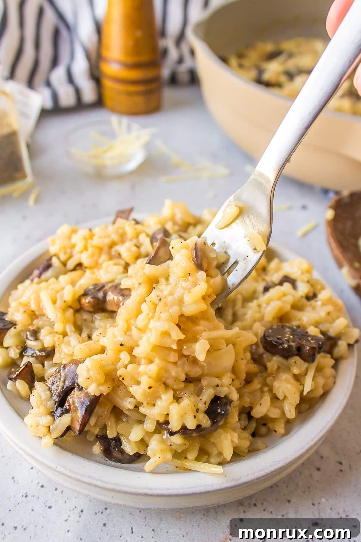 A fork taking a delicious bite out of the creamy mushroom risotto, highlighting its texture.