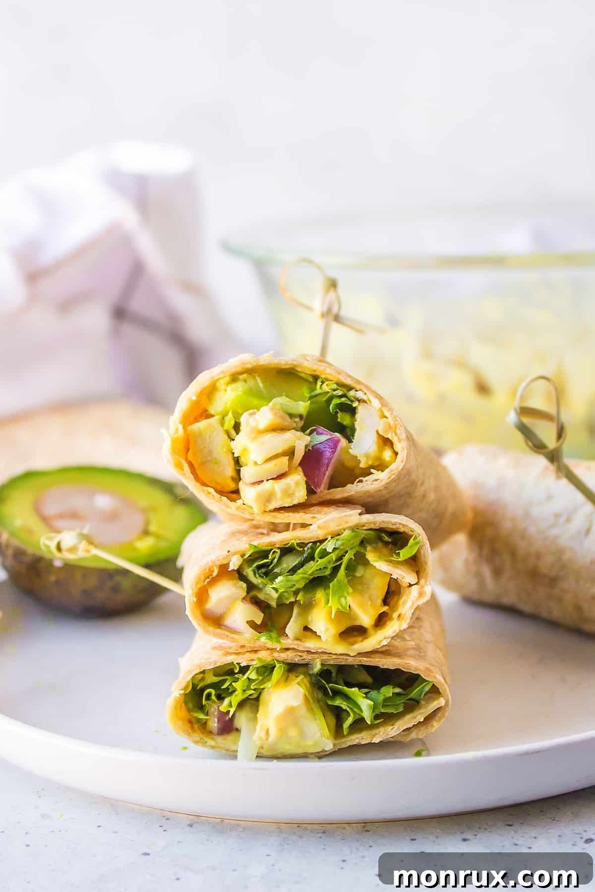 Two Honey Mustard Chicken Wraps, cut in half, arranged on a white plate with fresh lettuce and a side of dressing, showcasing a vibrant and appealing meal.