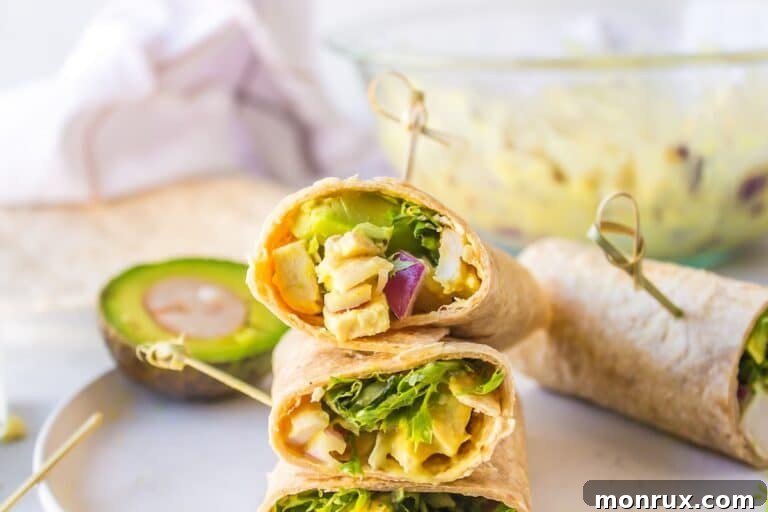 Two freshly prepared honey mustard chicken wraps, cut in half, stacked on a white plate ready to be served.