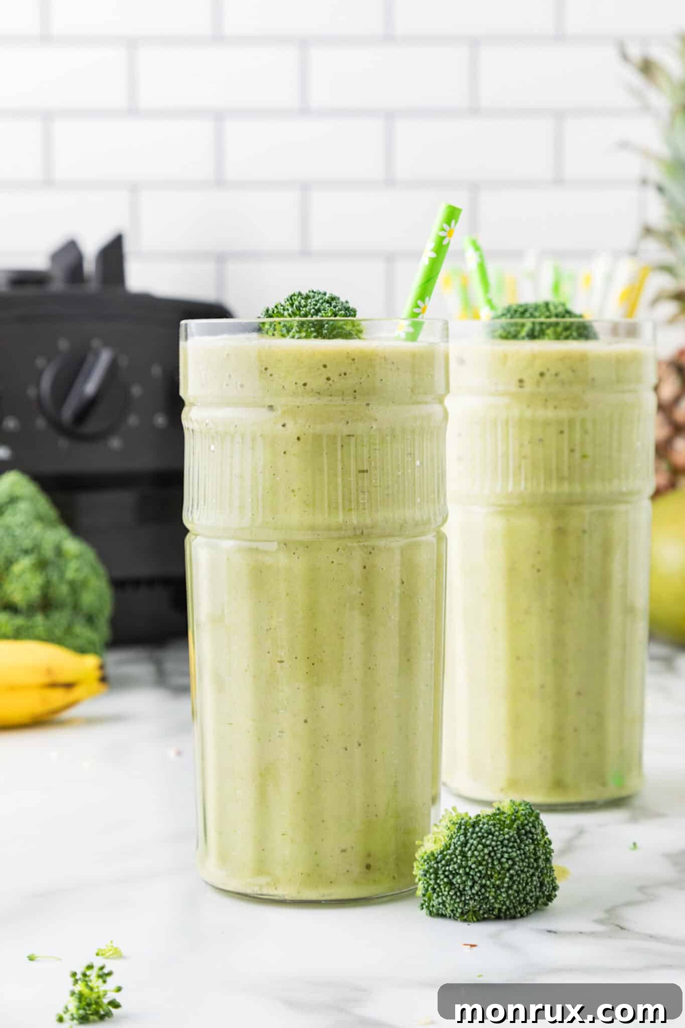 green broccoli pineapple smoothie in tall glass.