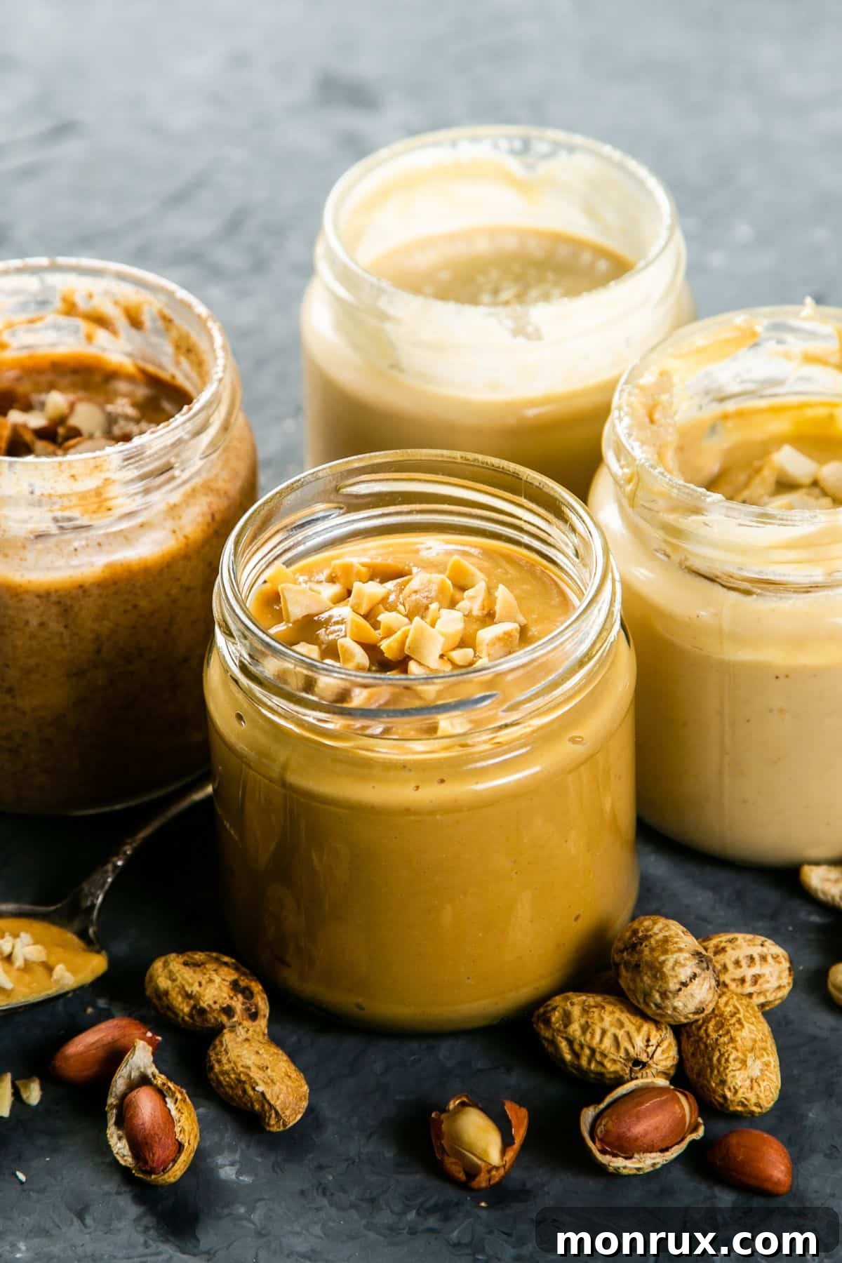 A visually appealing collection of various nut butters, including peanut, almond, and cashew, elegantly presented in glass jars.