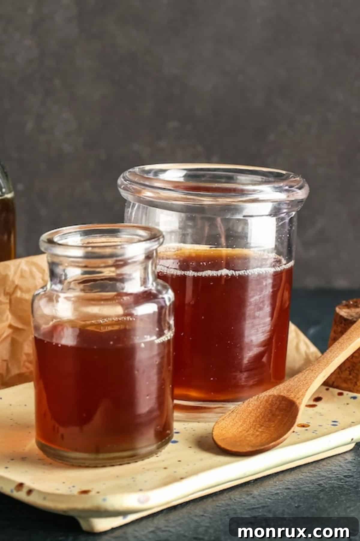 Two jars of golden coconut nectar on a rustic wooden table, showcasing its natural appeal and versatility as a liquid sweetener.