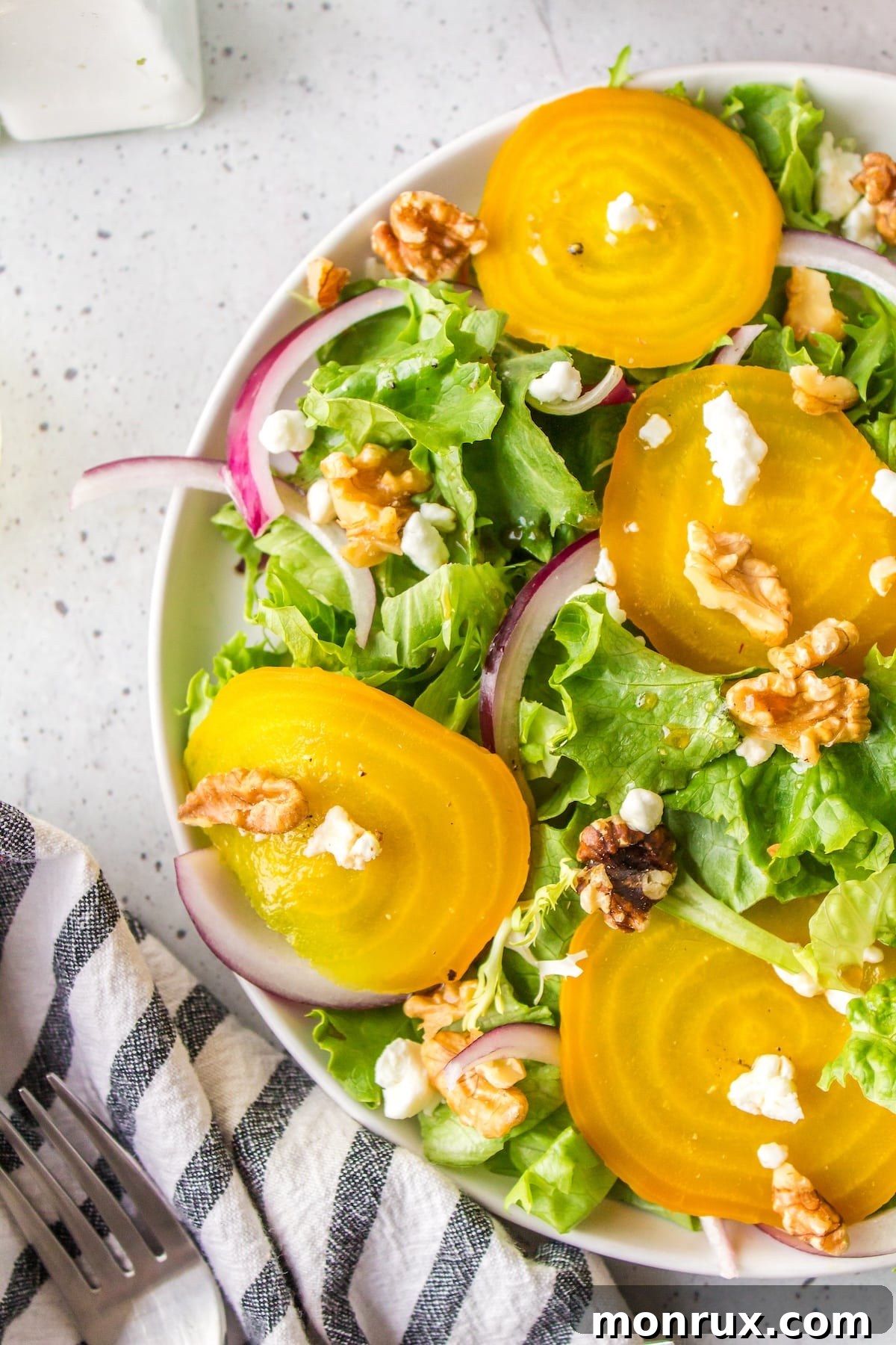 A close-up shot of the golden beet salad, showcasing its textures and fresh ingredients on a white plate.