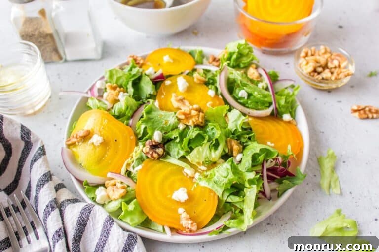 A beautiful white plate full of golden beet salad, ready to be served.