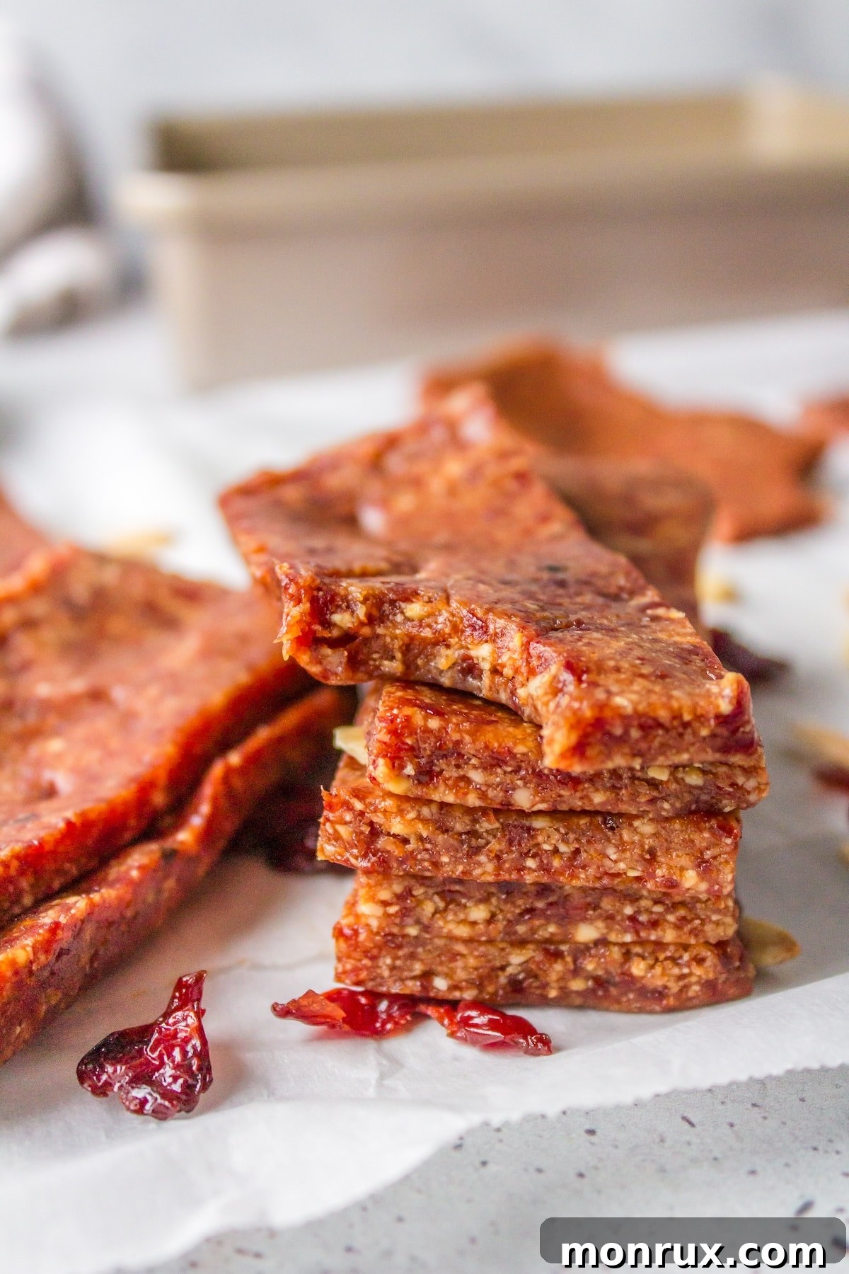 A stack of delicious almond cherry bars on a white counter, ready to be enjoyed as a healthy snack.