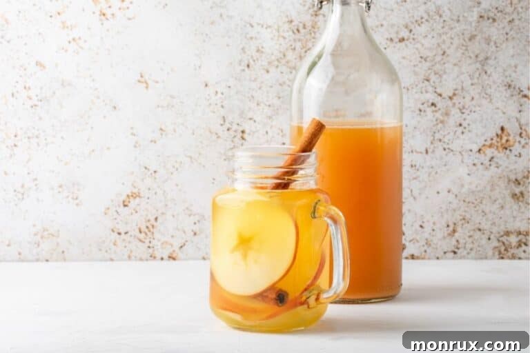 A comforting glass of apple cider vinegar tea with an apple slice and cinnamon stick, ready to be enjoyed.