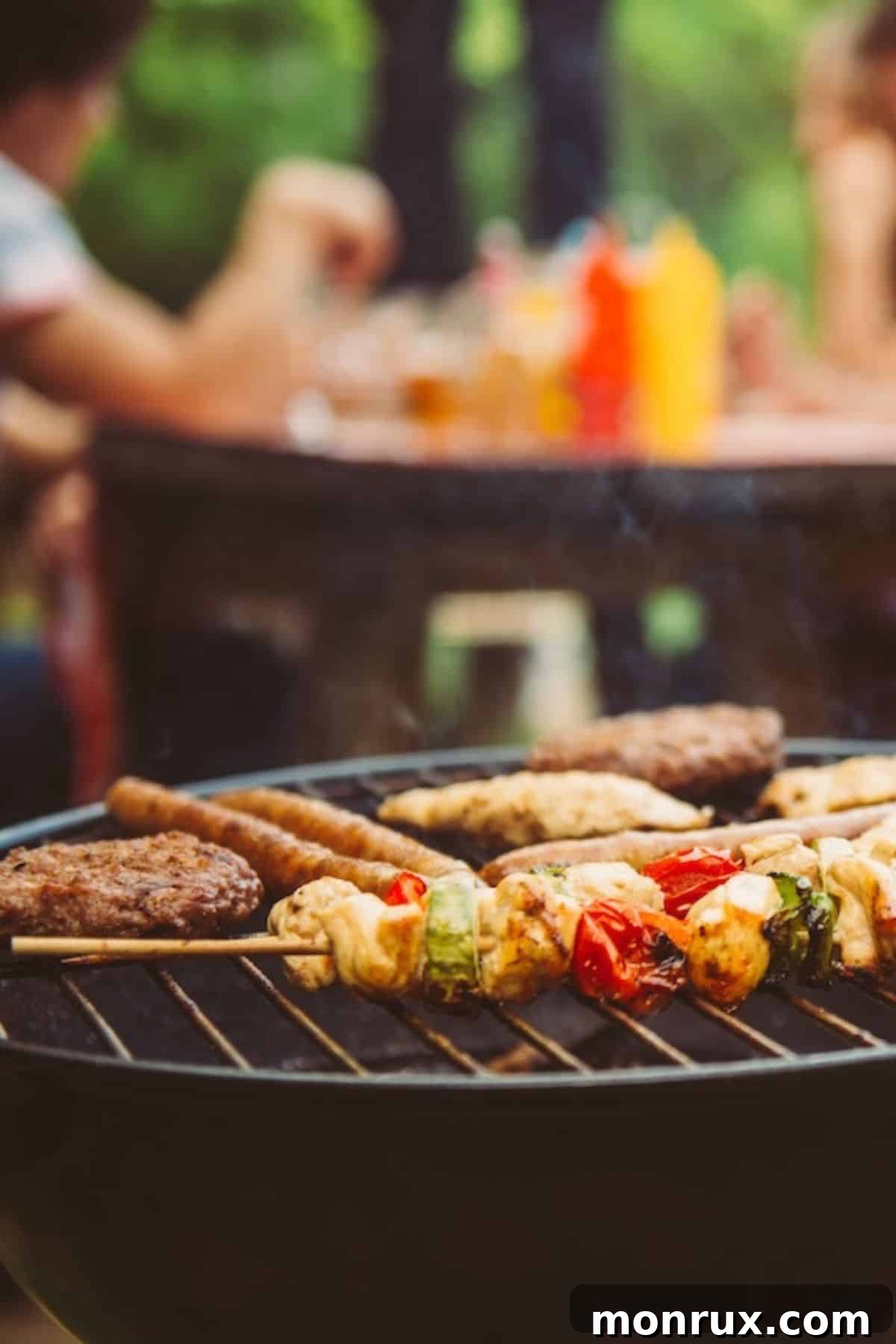 People enjoying an outdoor barbecue with kabobs cooking on a grill in a park setting.