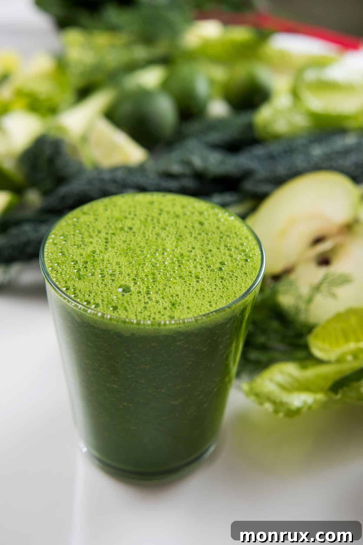 A refreshing glass of vibrant green juice, perfectly chilled and ready to invigorate your senses. It sits on a pristine white counter, highlighting its fresh appeal and clean ingredients, symbolizing a healthy start to your day or a perfect midday pick-me-up.