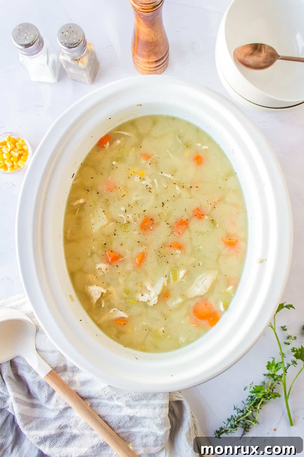 Creamy chicken, corn, and potato soup simmering inside a slow cooker, ready to be served.