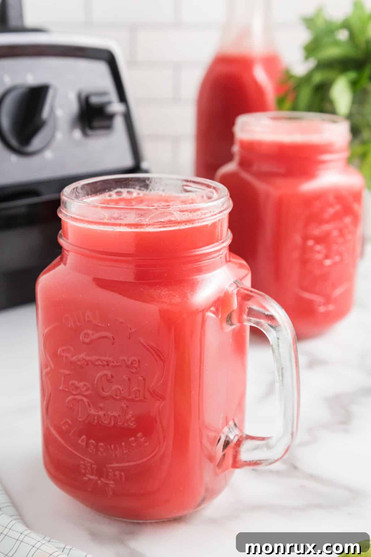 Fresh watermelon juice in a jar on a table, highlighting refreshing summer drinks.