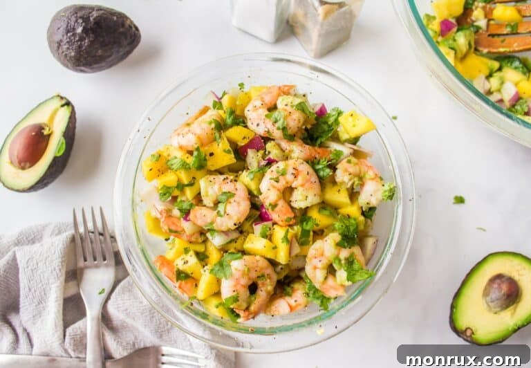 a bowl of avocado mango shrimp salad, ready to be served.