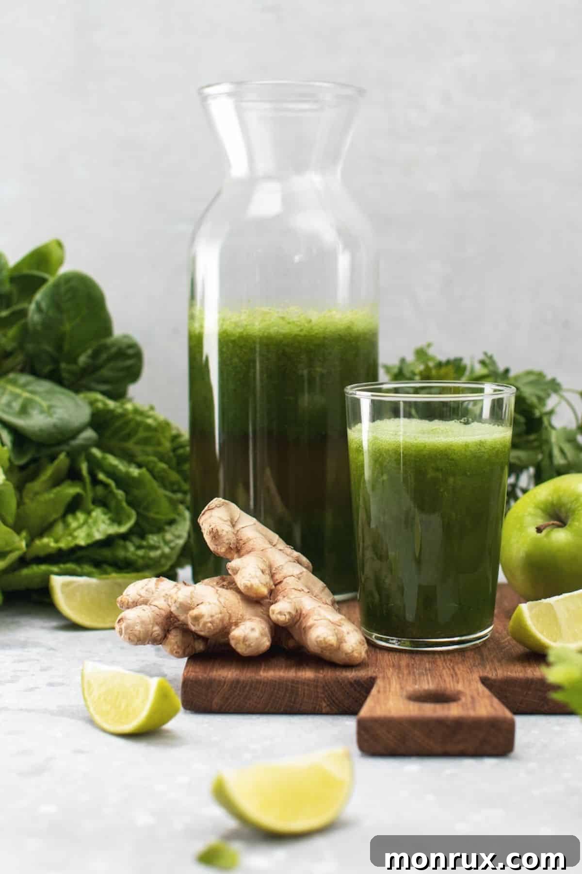 A crisp glass of vibrant green lettuce juice, garnished with a fresh lettuce leaf and a slice of lime, sitting on a natural wood surface with more fresh ingredients in the background.