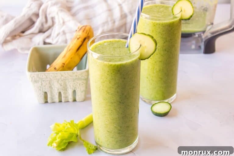 Two glasses of celery cucumber smoothie, garnished with a celery stalk.