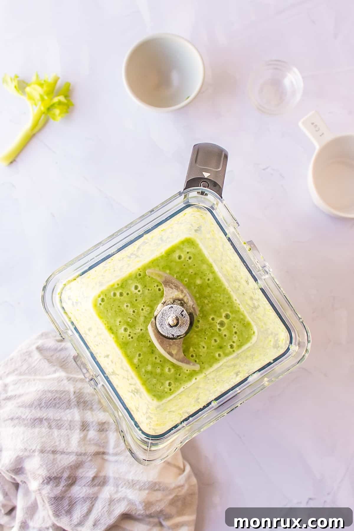 Blended smoothie ingredients inside a blender, showing a smooth and creamy green mixture.