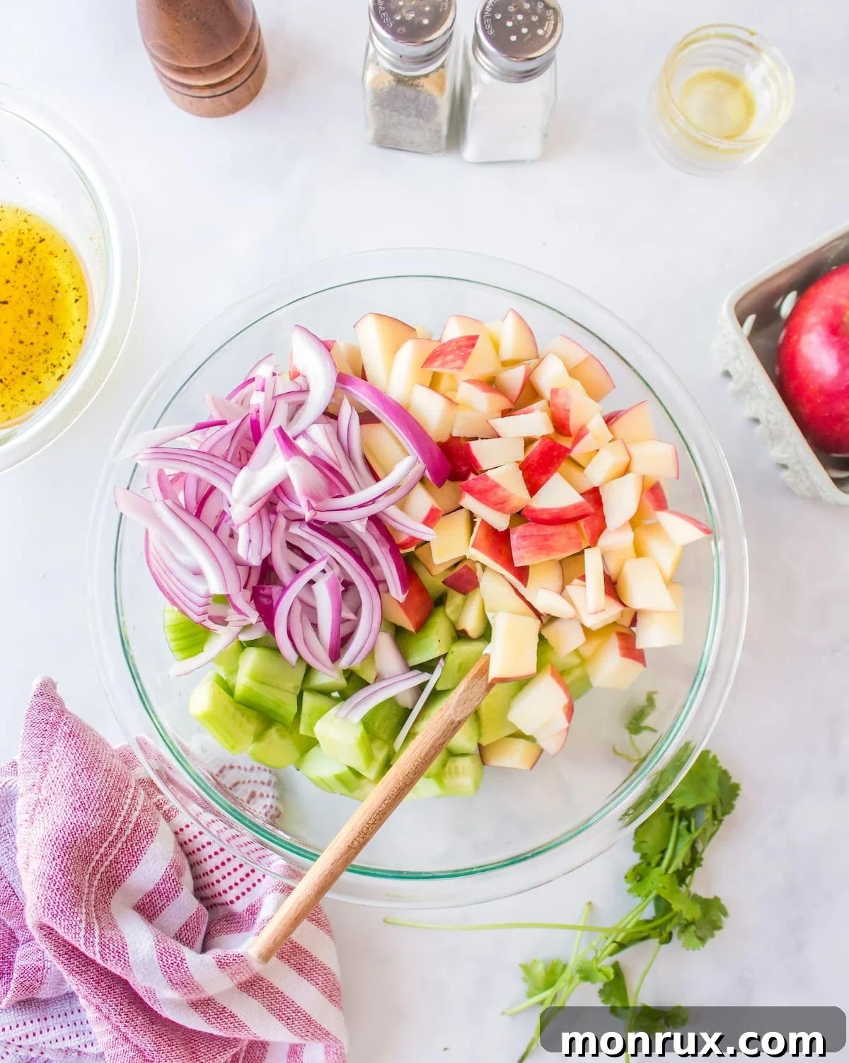 salad ingredients combined in clear bowl.