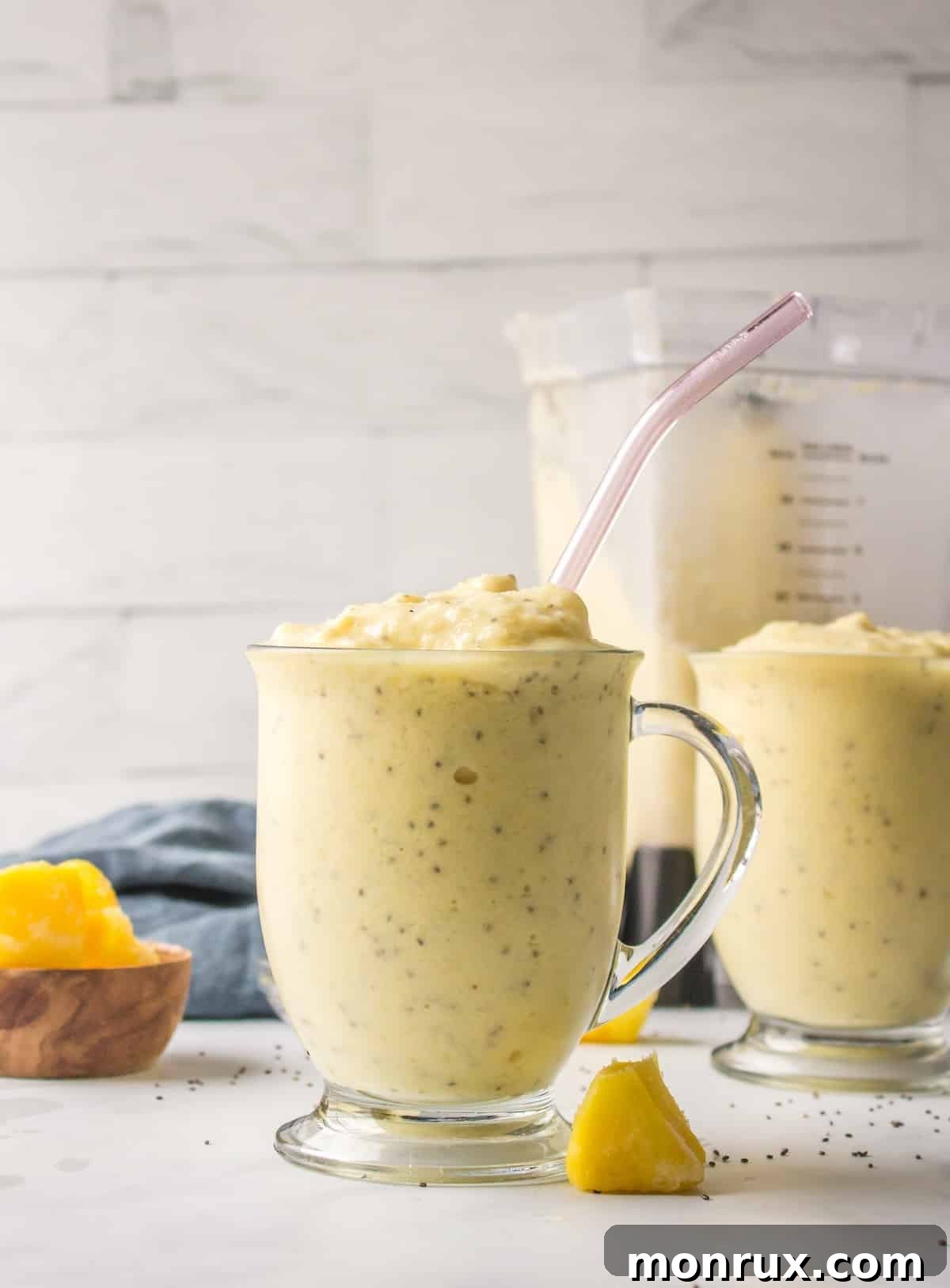 Close-up of a pineapple smoothie in a glass with a straw, ready for drinking.