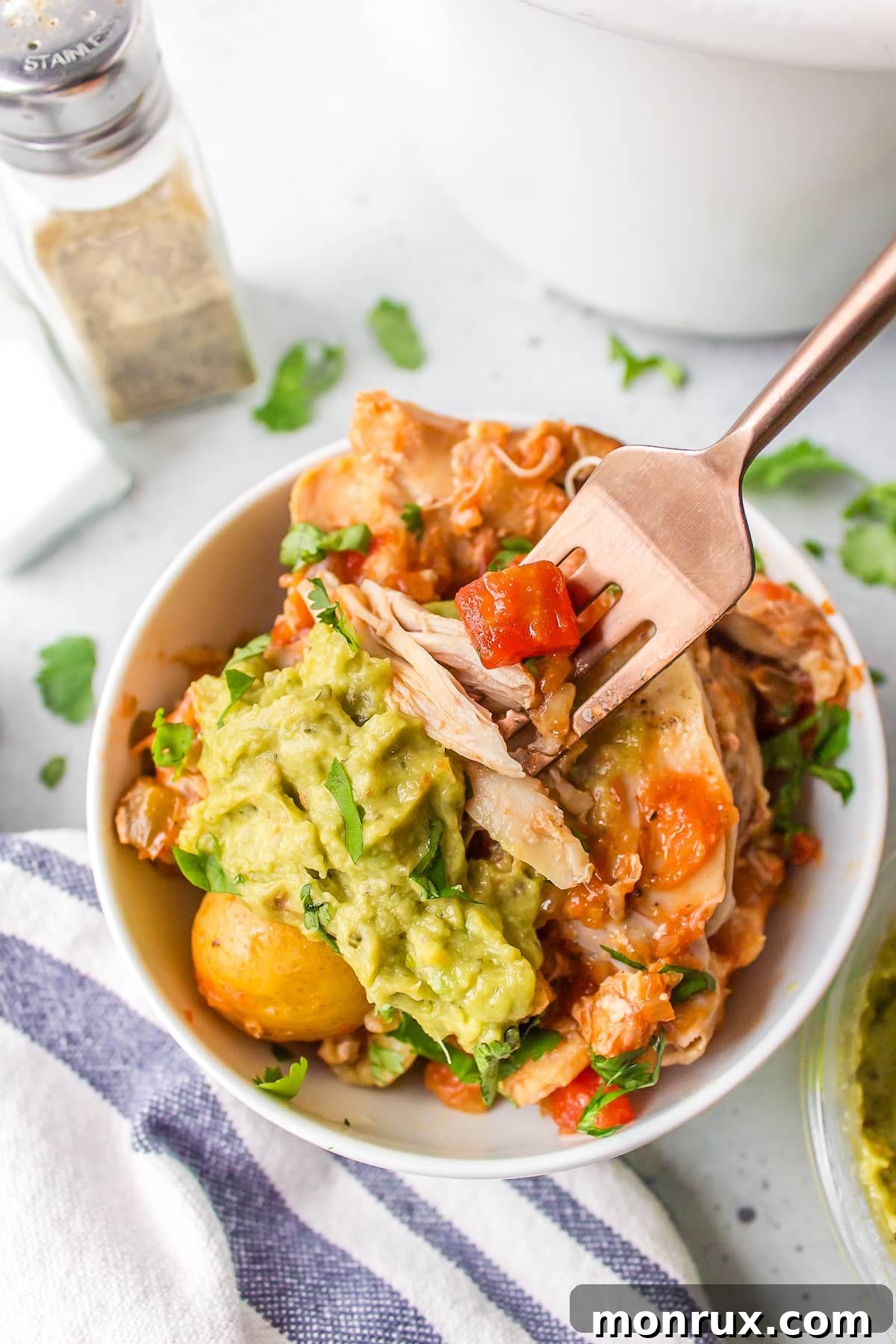 close-up bite shot of slow cooker chicken and potatoes, showing the tender chicken texture.