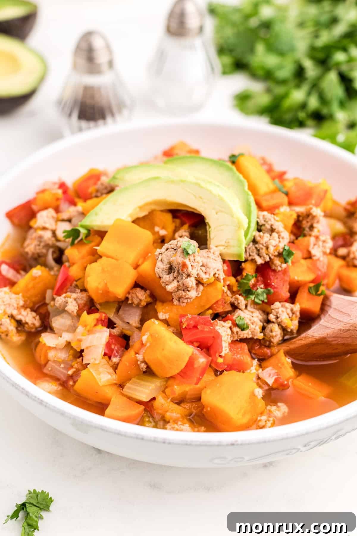 bowl of instant pot turkey chili topped with sliced avocado.