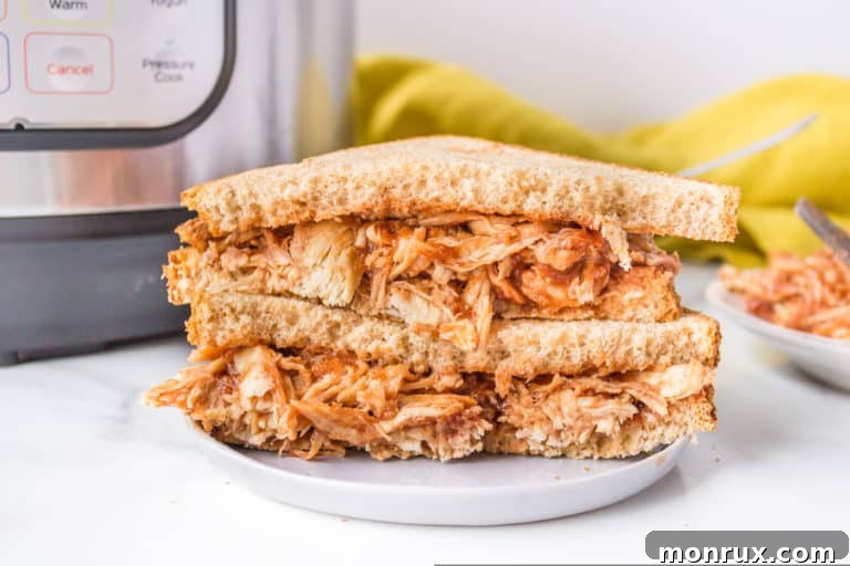 Tender Instant Pot BBQ Pulled Chicken, ready to be served on a bun or over a salad.