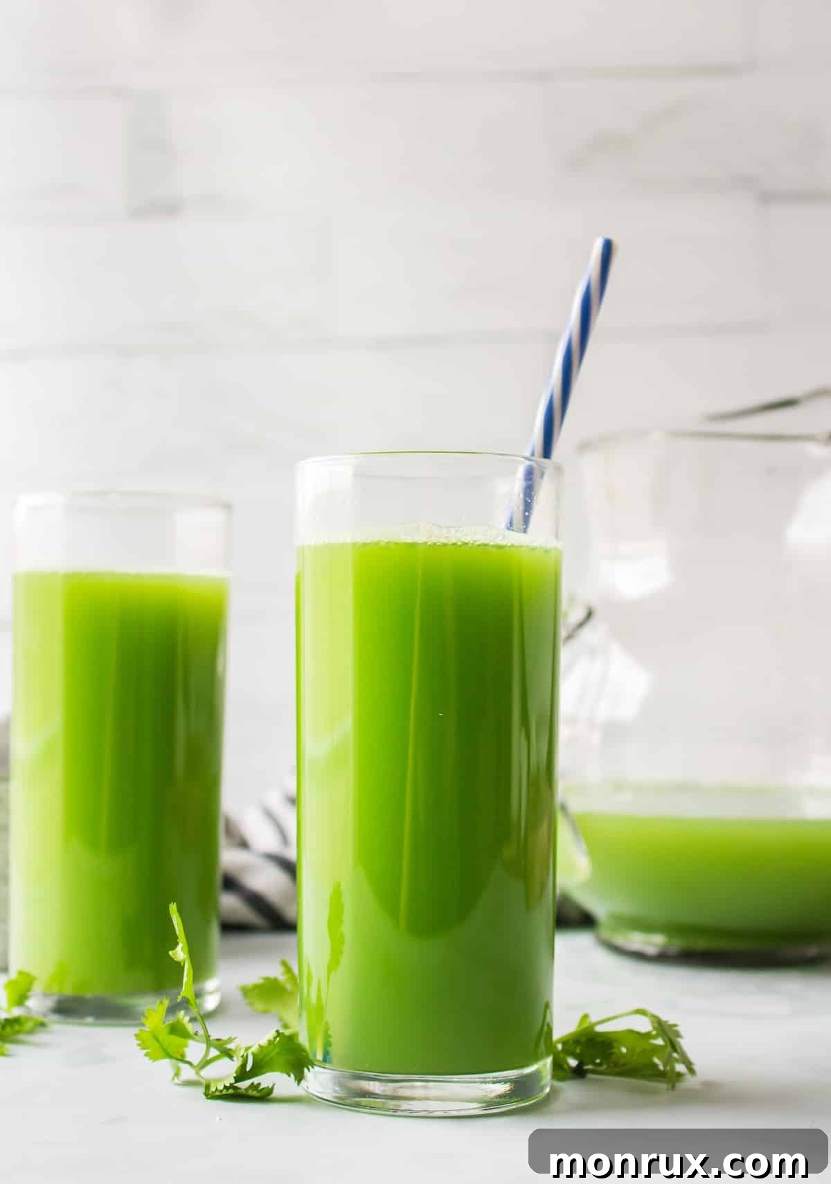 Fresh cilantro juice served in two glasses with garnishes.