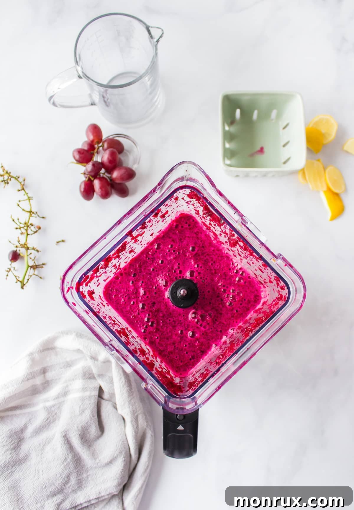 Step two of making purple juice: Either feeding prepped vegetables and fruits into a juicer or blending them in a high-speed blender.