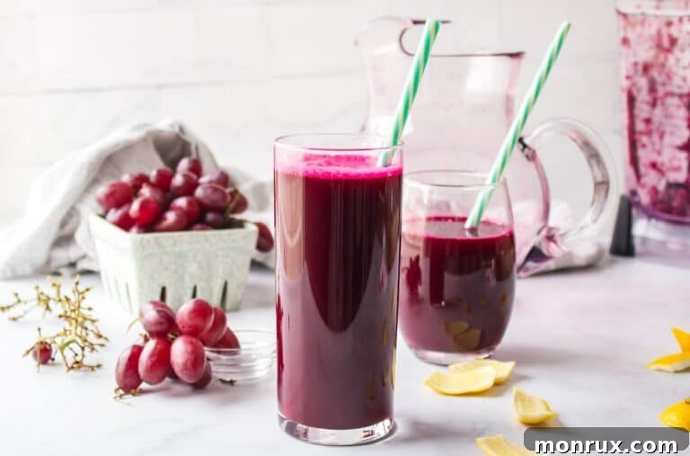Glasses of refreshing purple juice with straws, surrounded by fresh purple grapes, ready to be served.