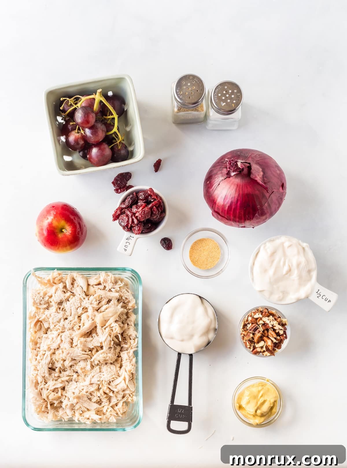 All the fresh ingredients for Apple Pecan Chicken Salad laid out on a wooden board.