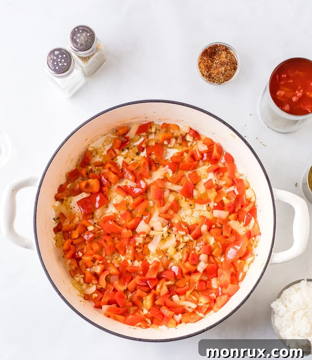 First step of cooking Unstuffed Pepper Skillet, showing onions and bell peppers sautéing in a large skillet.