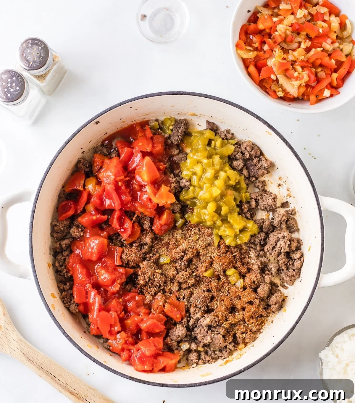 Second step of cooking Unstuffed Pepper Skillet, showing ground beef, diced tomatoes, and green chiles added to the skillet.