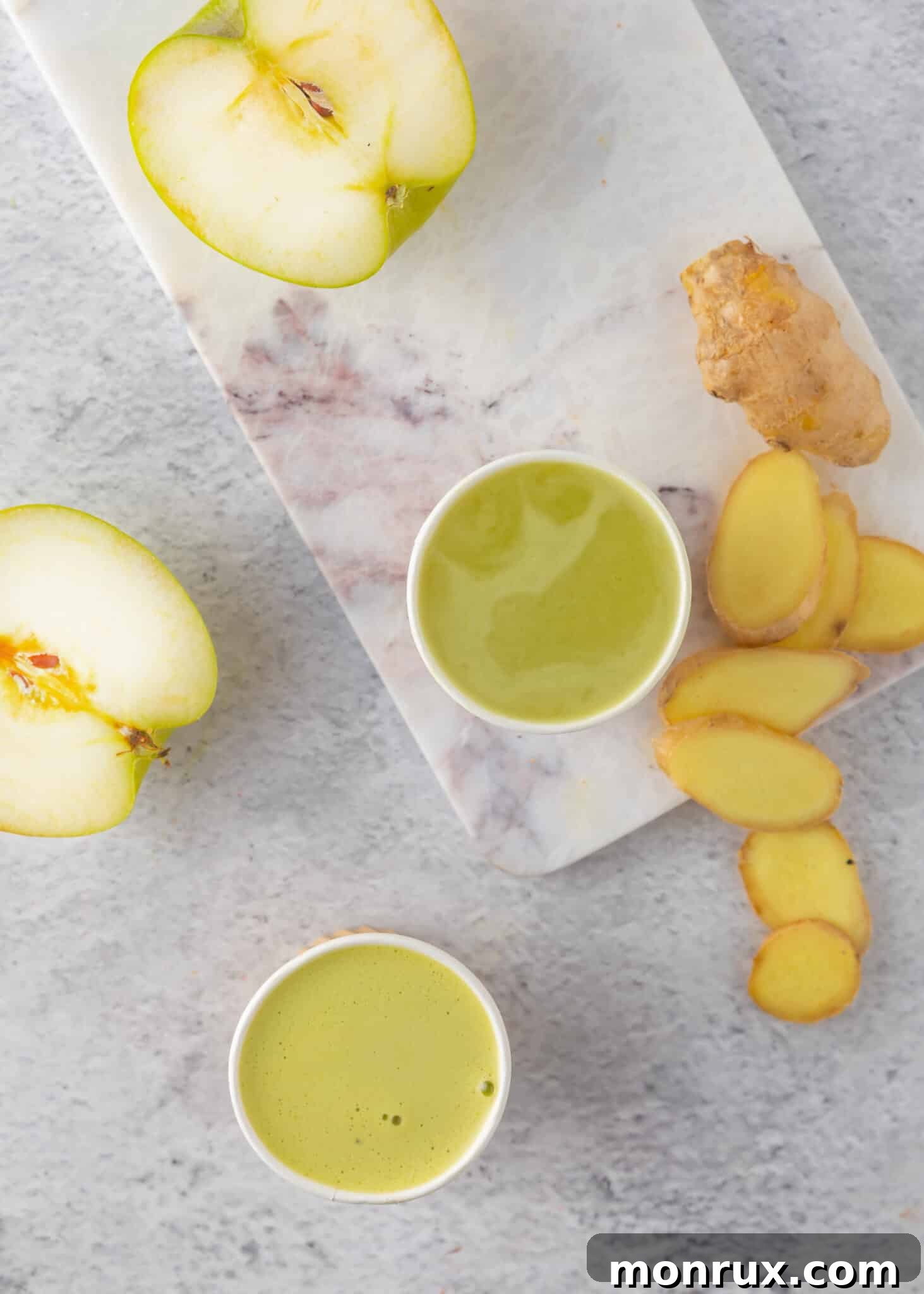 Two glasses of homemade apple ginger lemon juice, invitingly served.