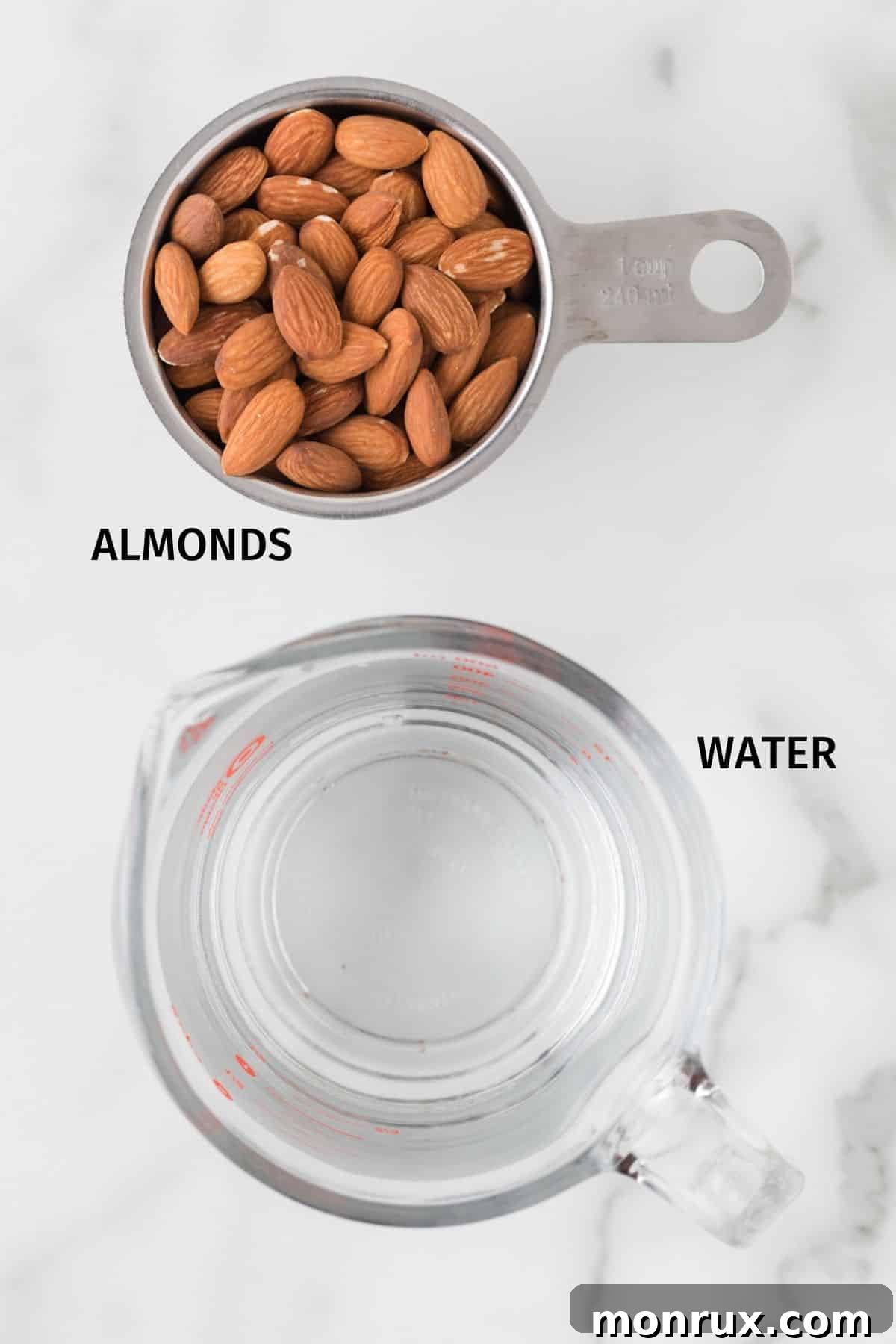 Raw almonds and a glass of filtered water, ingredients for making homemade almond milk.