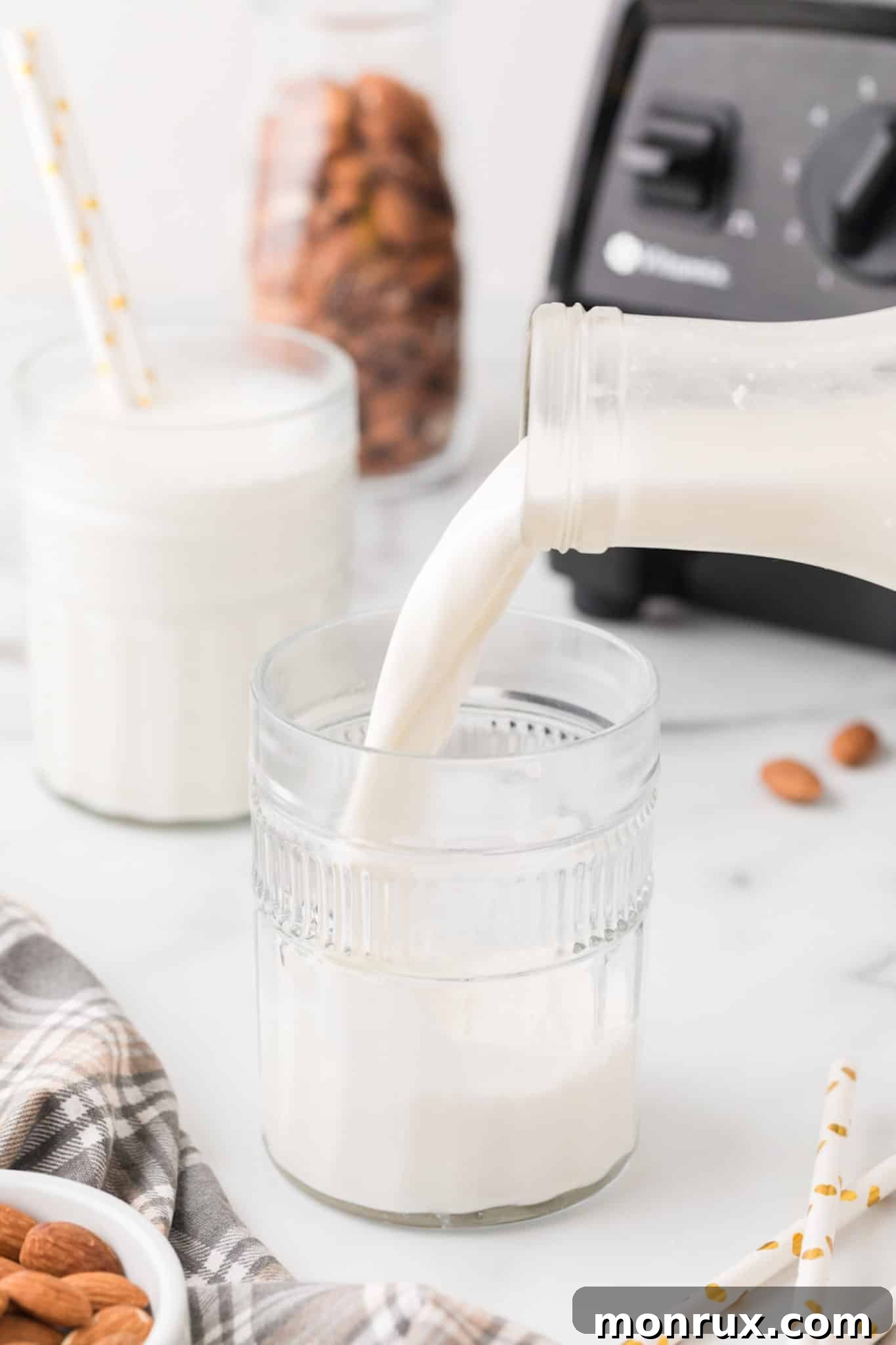 Pouring homemade almond milk into a glass.