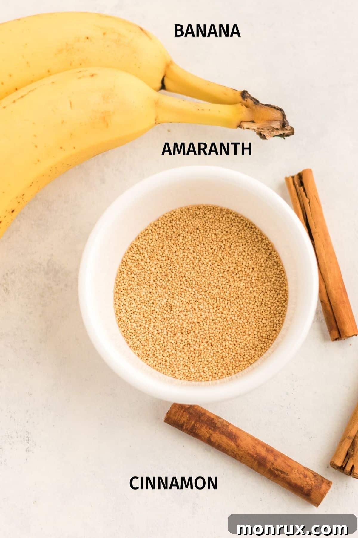 A flat lay photograph showcasing the key ingredients for amaranth porridge: uncooked amaranth seeds, sliced ripe bananas, and a carton of plant-based milk.