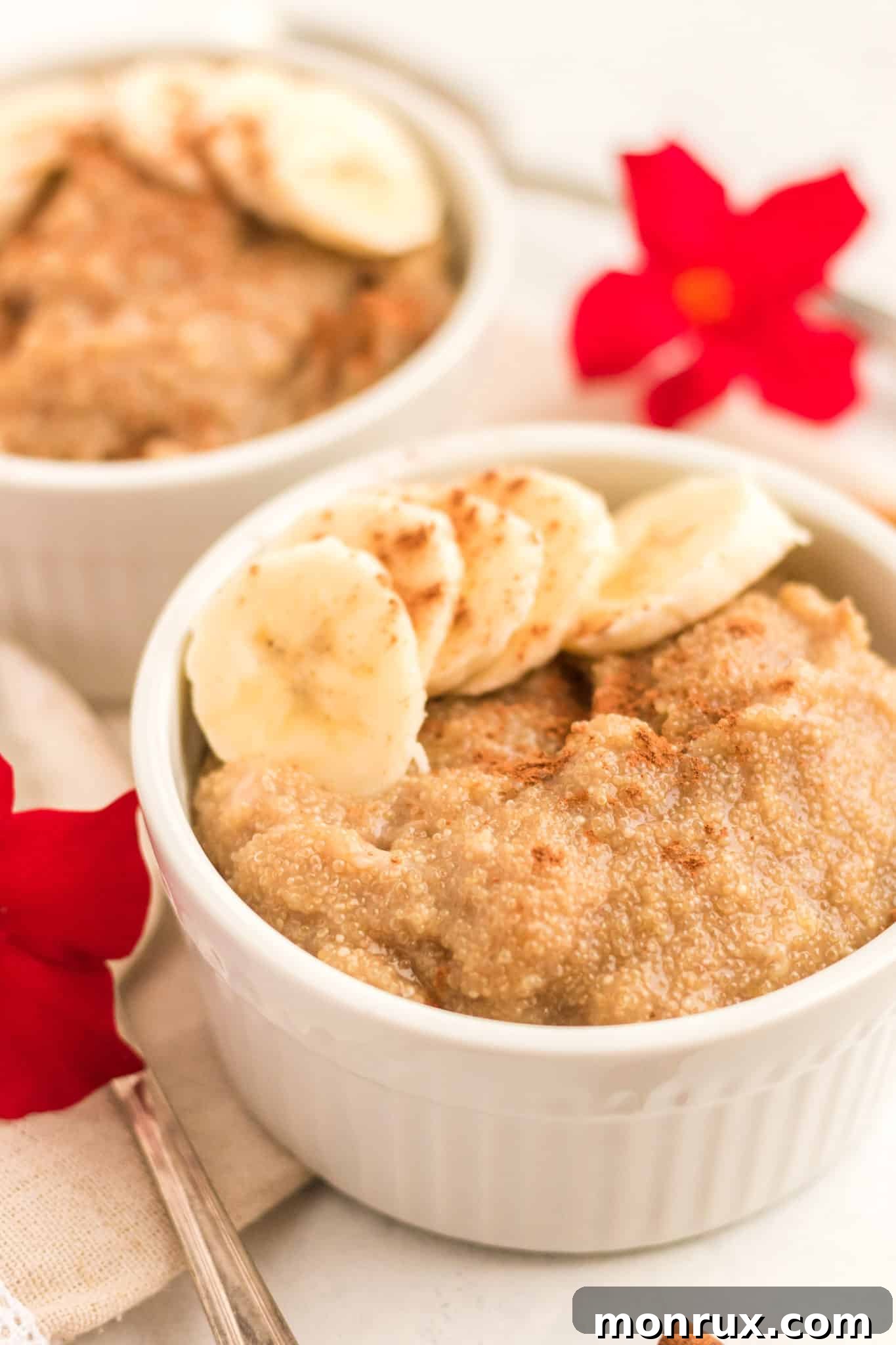 A close-up of a bowl filled with creamy amaranth porridge, garnished with elegantly sliced bananas and a light dusting of cinnamon.