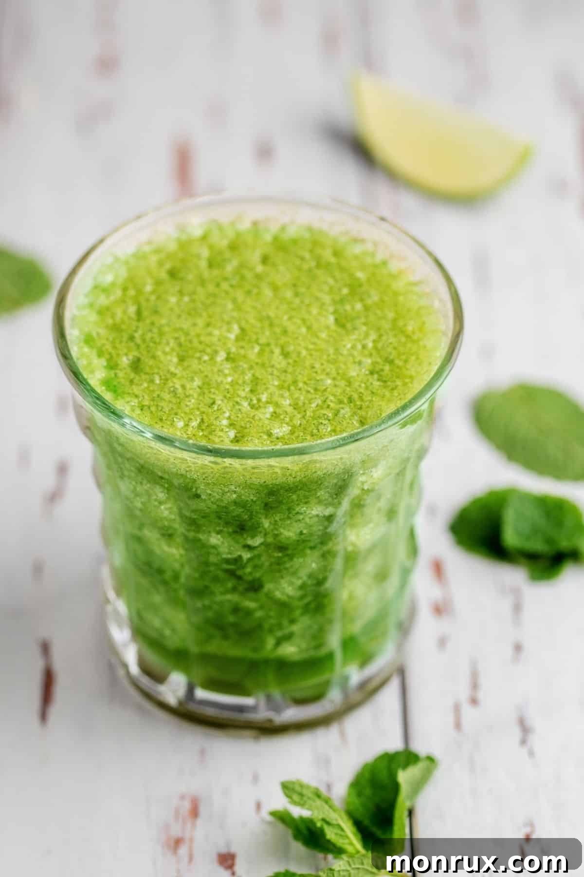 mint juice in shot glass on table.